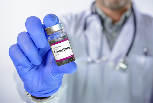 Doctor has Fentanyl ampoule in hand. Fentanyl is an opioid used as pain medication and for anesthesia. It is also used as a recreational drug mixed with heroin or cocaine.