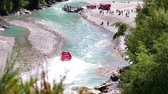 Speedboat jet boat in river in canyon. New Zealand extreme sport for thrill seekers, adventure travel, backpacking. 