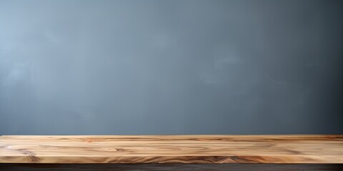 Gray background with empty wooden table top, used for displaying or arranging products.