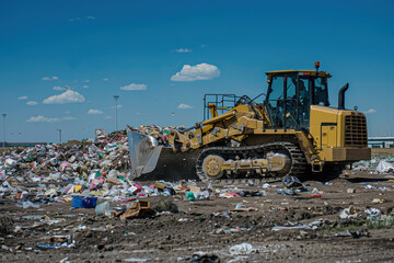 Fototapeta premium A large yellow dump truck is driving through a pile of trash. Image created by IA