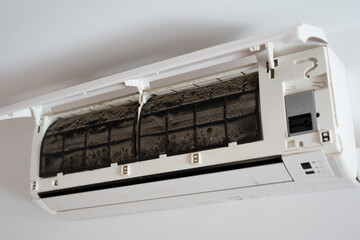 Dirty in dust and mold air conditioner filter close-up. Home air conditioner maintenance