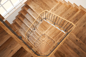 Elegant Overhead Perspective of a Modern Wooden Staircase with Iron Railing