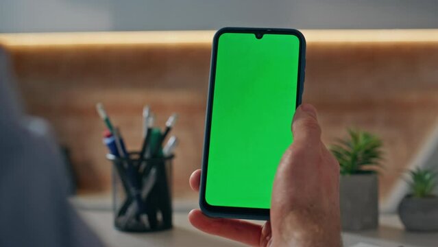 Unknown guy looking chroma key cellphone working at company office alone closeup