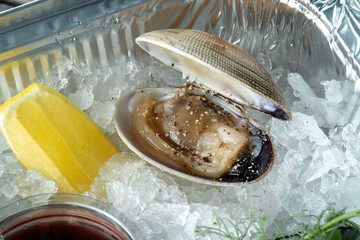 Raw uncooked clam shell shellfish with ingredients.