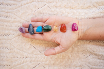 Healing crystals on female hand background, seven chakra stones.