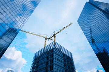 Towering Construction Crane amid Emerging Skyscrapers Under Blue Sky