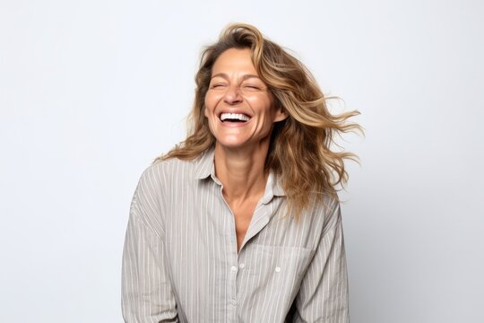 Portrait of a happy mature woman laughing with closed eyes on white background
