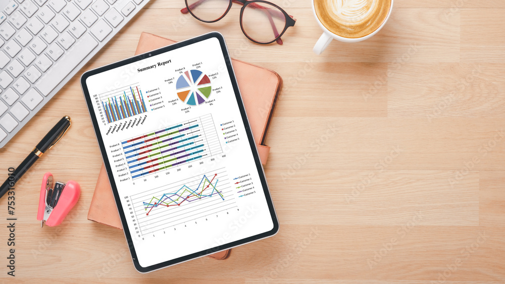 Poster an organized workspace featuring a tablet with detailed analytical charts, next to office essentials