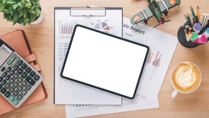 Overhead view of a well-organized desk featuring a digital tablet with a blank screen, financial...