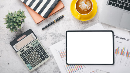 Overhead view of a well-organized desk featuring a digital tablet with a blank screen, financial...