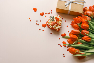 Birthday cake, bouquet of red tulips and envelope with letter, holiday gift