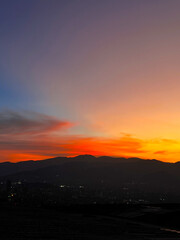 Colorful sunset with blue and orange sky. View of the city of Medellin.