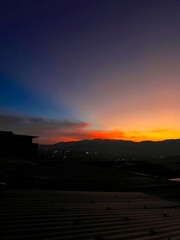 Colorful sunset with blue and orange sky. View of the city of Medellin.