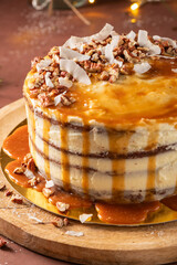 Delicious salted caramel cake with pecan nuts and coconut flakes