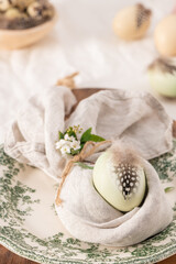 Stylish Easter brunch table setting with egg in easter bunny napkin.
