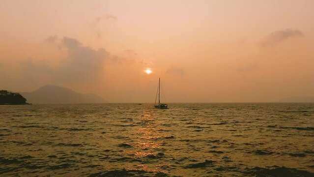 February 1, 2024 - Rawai, Phuket Thailand. Sunrise from the landing pier on a hazy morning.