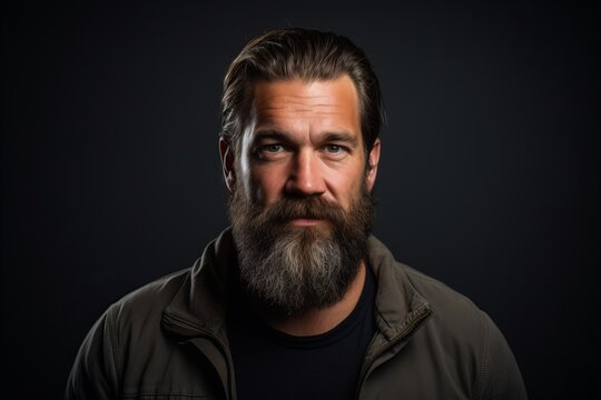 Portrait of a handsome man with long beard and mustache on a dark background