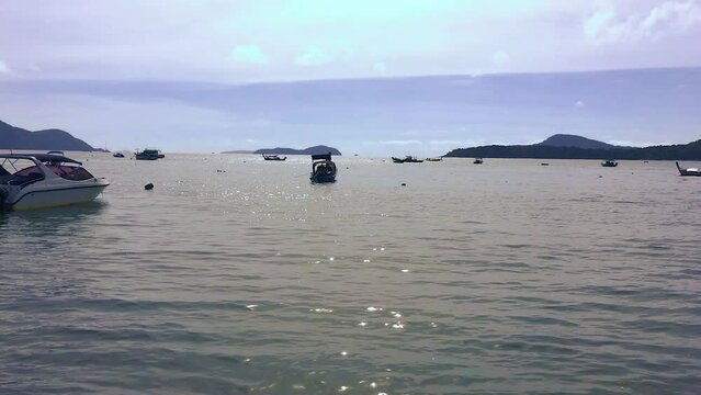 January 17, 2024 - Rawai, Phuket Thailand. Boats anchored in the sun off the shore of Rawai.