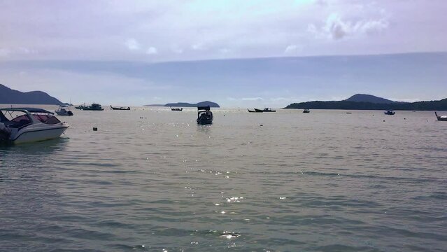 January 17, 2024 - Rawai, Phuket Thailand. Boats anchored in the sun off the shore of Rawai.