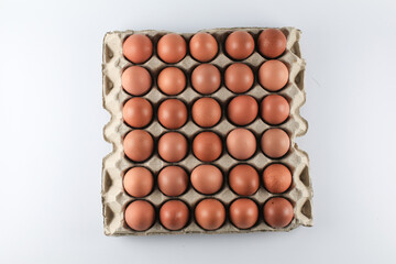 Raw chicken eggs in egg carton on white background. Natural healthy food and organic farming concept.