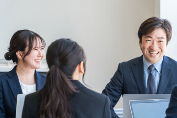 企業のオフィスで笑顔で会議・ミーティング・商談をする
