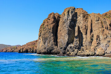 Rocky coast in the resort part of the Mediterranean or Aegean Sea. Background with selective focus and copy space