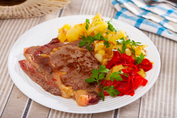 Fototapeta premium Homemade veal steak with fried potato and marinated red pepper