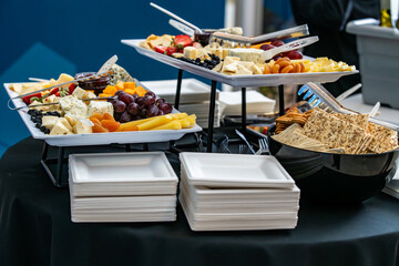 A tray of cheese and crackers and fruit on display catered for snacks