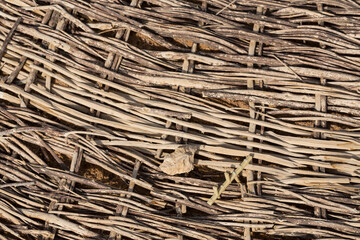 Weaving of twigs of branches. A man-made background smoldering on the ground.
