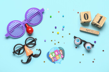 Calendar with funny glasses and decor on blue background. April Fools Day