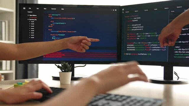 Slow motion back end software developer engineer for computer programming working together on debugging writing computing code, solving complex algorithms display on monitor in office. Burgeoning