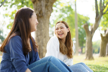 Naklejka premium Women relaxing together at park.