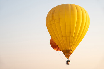 Yellow hot air balloon in flight against the sky.