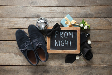Chalkboard with text PROM NIGHT, male shoes and gift box on wooden background