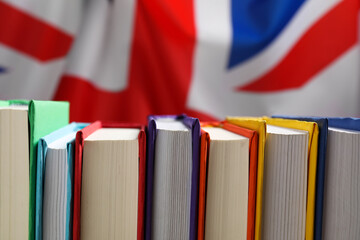 Learning foreign language. Different books against flag of United Kingdom, closeup