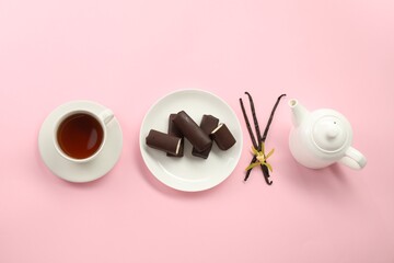 Glazed curd cheese bars, vanilla pods and tea on pink background, flat lay