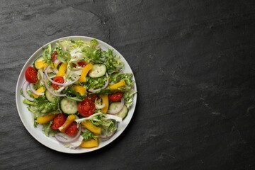 Tasty fresh vegetarian salad on black table, top view. Space for text