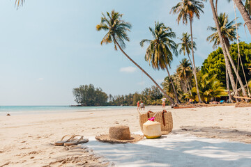 Beach and tropical paradise with a coconut resting on the sand and a refreshing coconut cocktail...