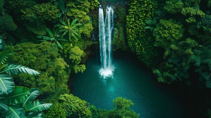 Fototapeta premium Bird's-eye view of a majestic waterfall plunging into a turquoise pool