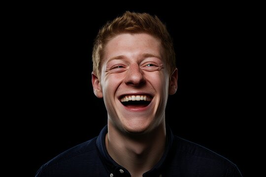 Portrait of a young red-haired man on a black background