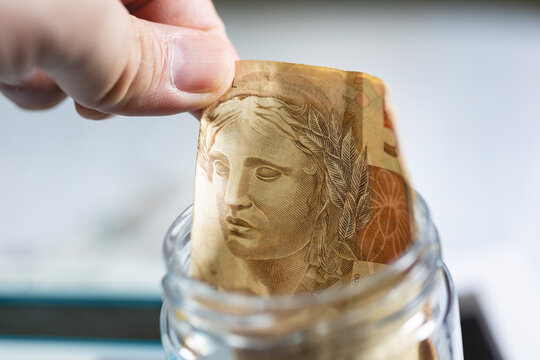 Uma nota de 50 Reais em um pote de vidro. Real Brasileiro - BRL, Dinheiro - Brasil. C&eacute;dula, Nota, economia.