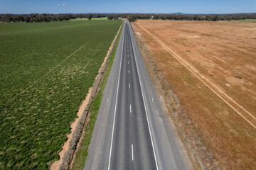 empty road with different landscape fro both sides. One side is brown another is green 
