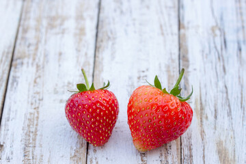 Fresh strawberries on old white wooden background.