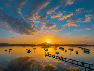 Aerial sunrise waterscape with boats, reflections and low cloud