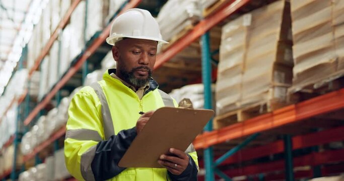 Walking, warehouse and black man with clipboard for inspection, inventory and check stock. Shipping, distribution and person writing checklist for logistics, maintenance and manufacturing in factory