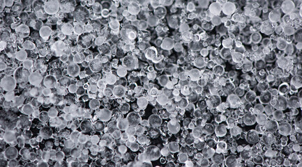 Large grains of hail on black background. Background, texture.