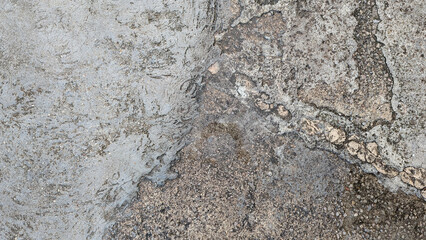 Top view of old and rough floor of various gray cement mixes with gravel stone. Concrete floor with moisture stains, lichens and moss texure or background.
