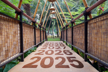 Bamboo pedestrian bridge with signs for the years 2025 to 2029. Concept towards the new year 2025.