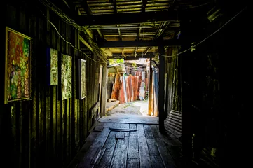 Fotobehang Gang Wooden walkway in a small alley with light shining through of Chum Saeng District  © Kobchai M.