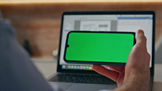 Man hand touching chroma key screen chat desk closeup. Freelancer tapping cell